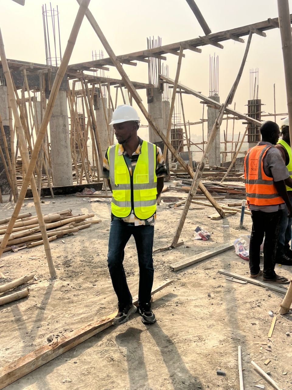 On the first floor slab with rebar cages and the site team